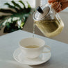 Pouring tea from teapot to cup